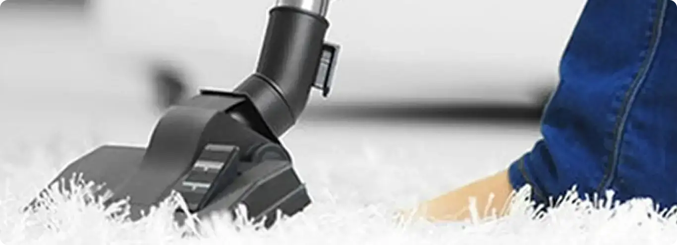 Close-up of a professional vacuuming a white carpet in Darien.